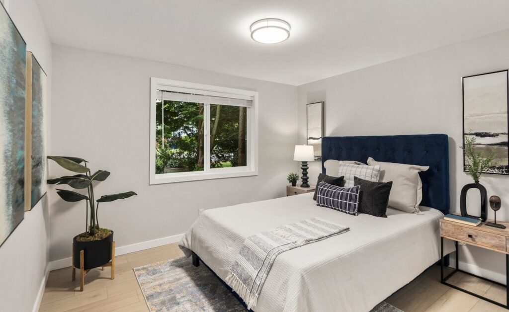 Bedroom with a navy tufted headboard and a garden view