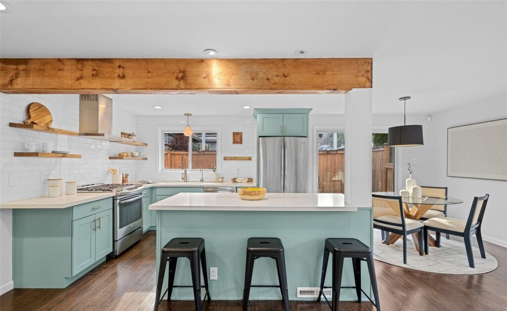 Kitchen with a sea-green island, open shelving and a dining table beyond