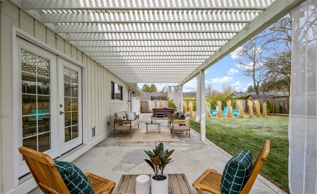 Covered patio with outdoor seating overlooking the backyard