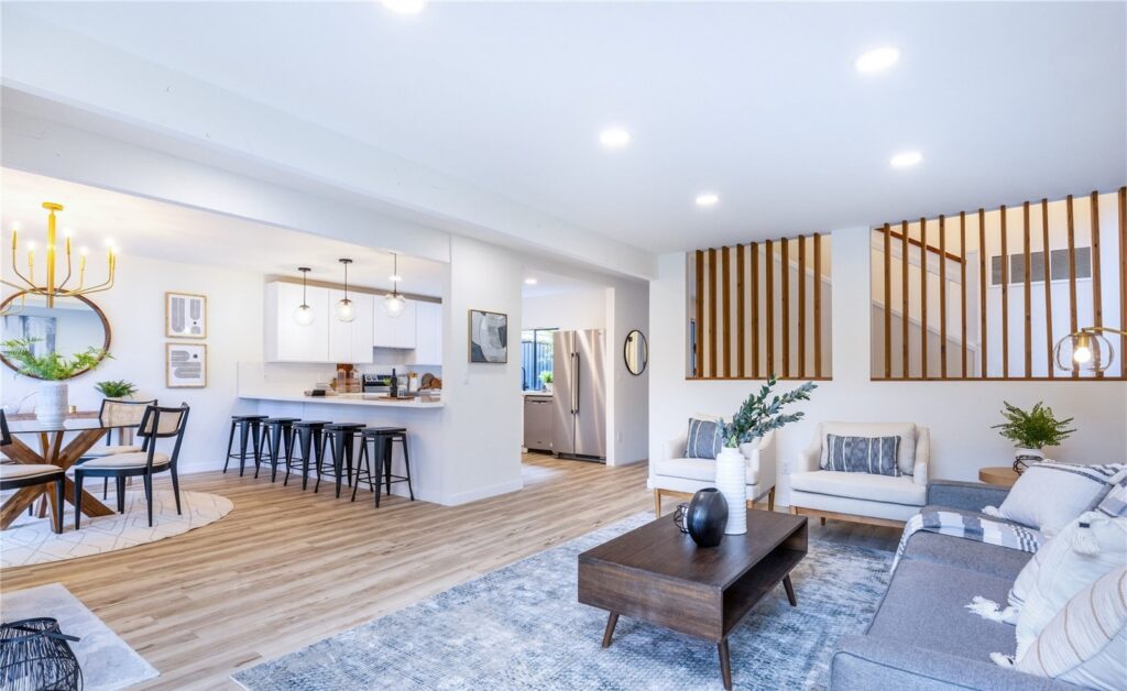 Dining area and kitchen with a round table, brass pendant and counter stools