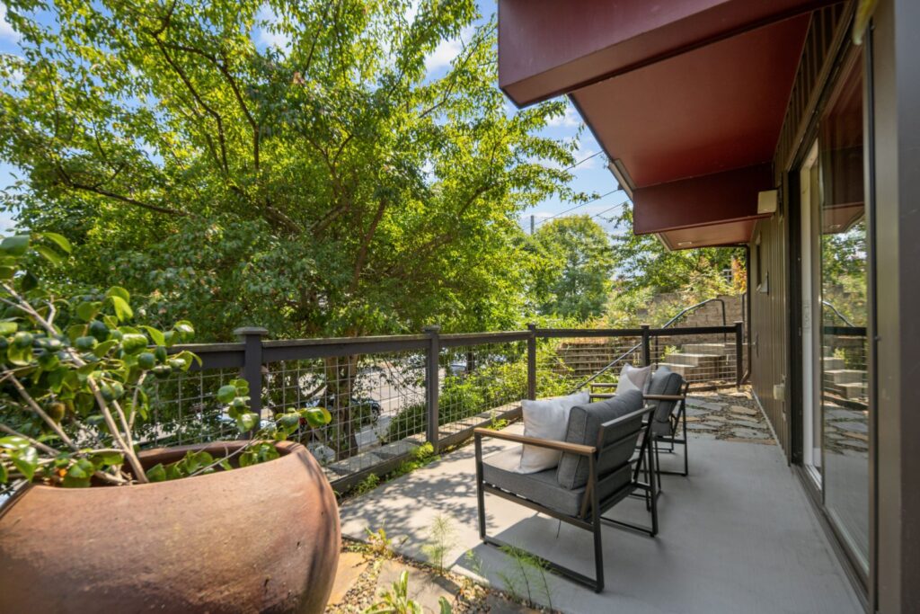Deck with outdoor seating surrounded by greenery