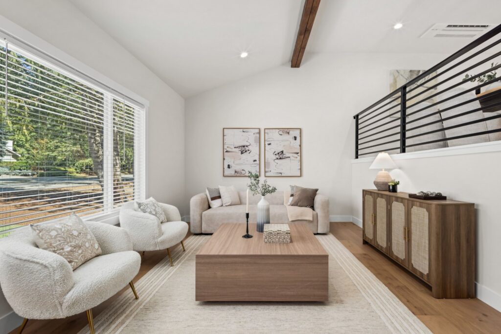 Redmond home staging in a living room with a vaulted ceiling, oversized sofa, accent chairs and paired art