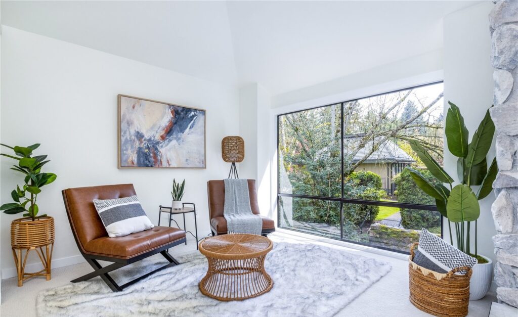 Staged living room with accent chairs, round table and large windows in a Redmond home, by IntExt Staging