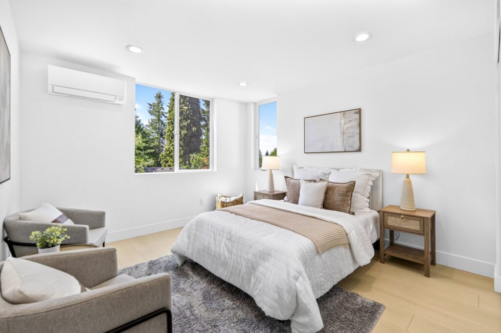Bedroom with layered bedding, an accent chair and art in a Seattle townhouse
