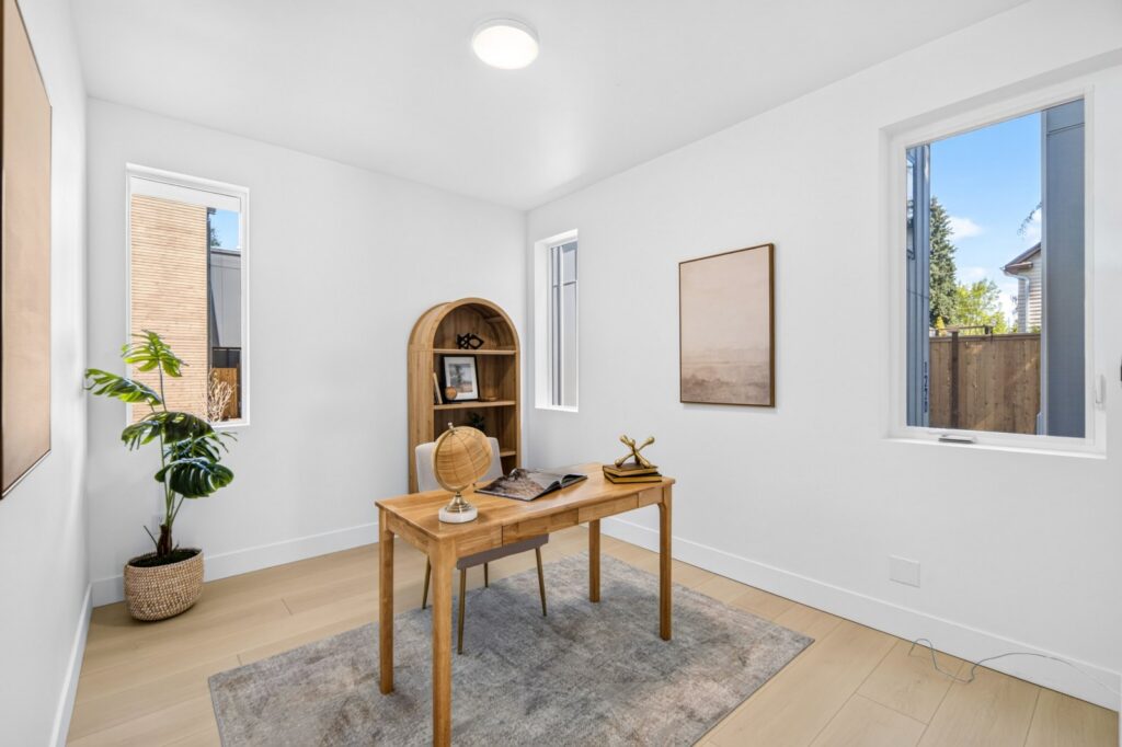 Office staged with a desk, arched bookcase and rug, showing how a home stager gives every room a purpose