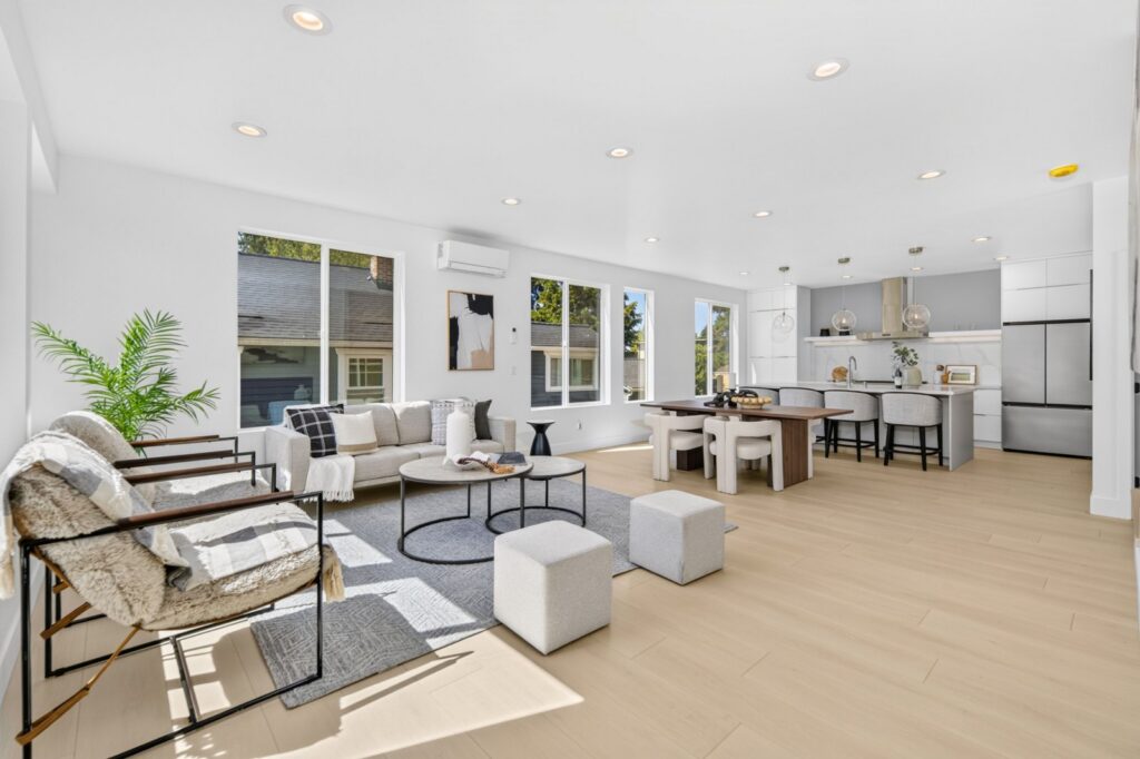 Open living room with a sofa, round coffee tables and the dining area beyond, in a Seattle townhouse