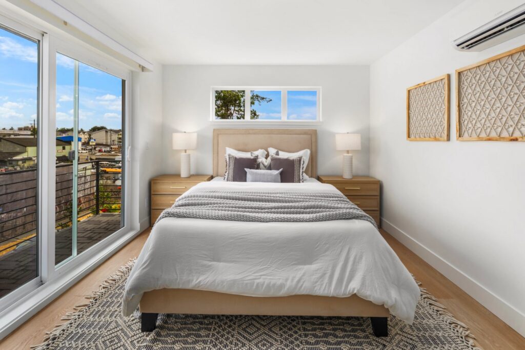 Seattle bedroom with an upholstered bed, layered bedding, warm lamps and a patterned rug