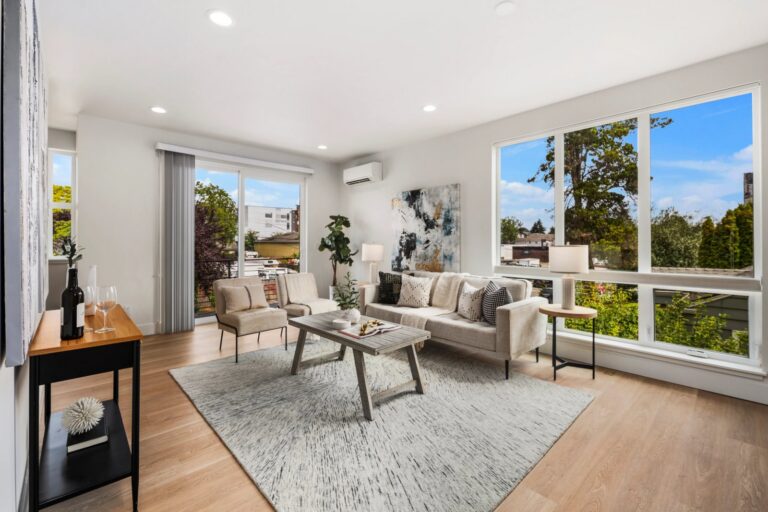 Staged living room with a rug, sofa and wall of windows in a Seattle home, showing how to stage a condo-style space