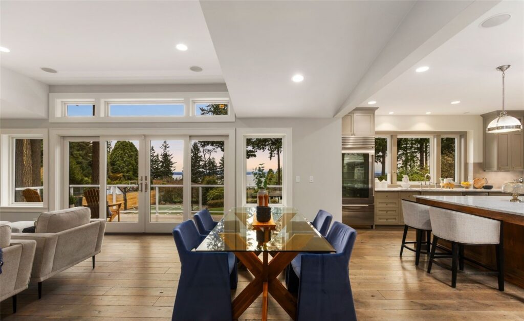 Staged dining room with blue upholstered chairs and glass table in a Seattle home, by IntExt Staging
