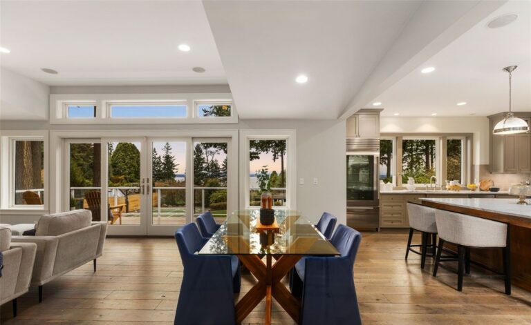 Staged dining room with blue upholstered chairs and glass table in a Seattle home, by IntExt Staging