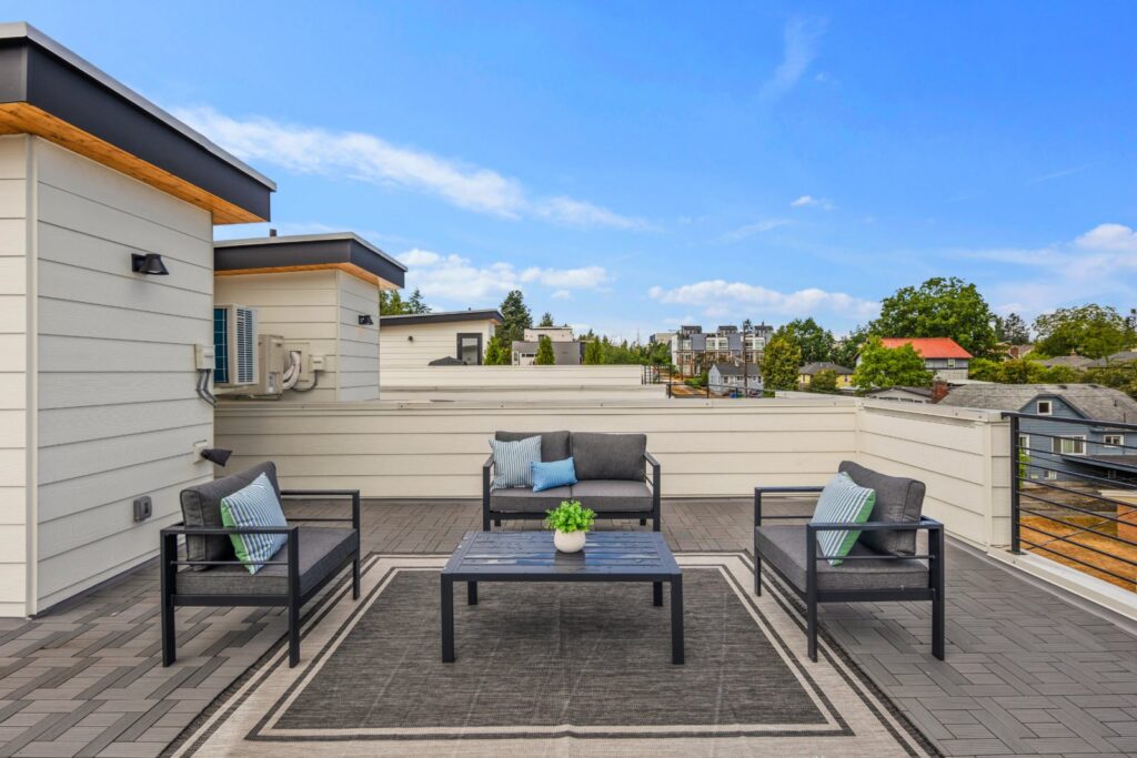Staged rooftop deck in Seattle with lounge chairs, a coffee table and an outdoor rug, by IntExt Staging