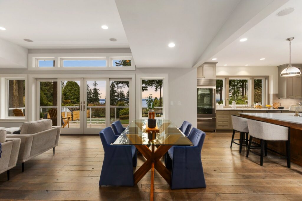 Seattle dining room with navy chairs and a glass table by French doors
