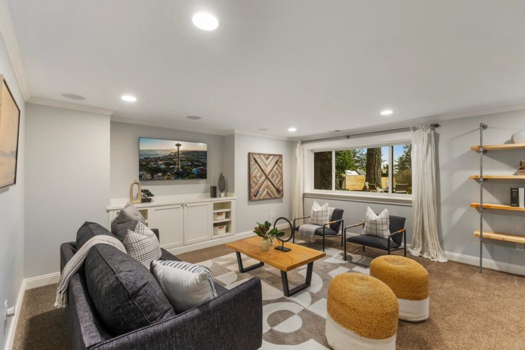 Seattle lower-level living space with a sofa, accent chairs and open shelving